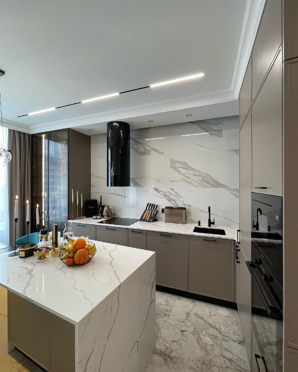 Бежевая кухня с островом и столешницей из искусственного камня - фото