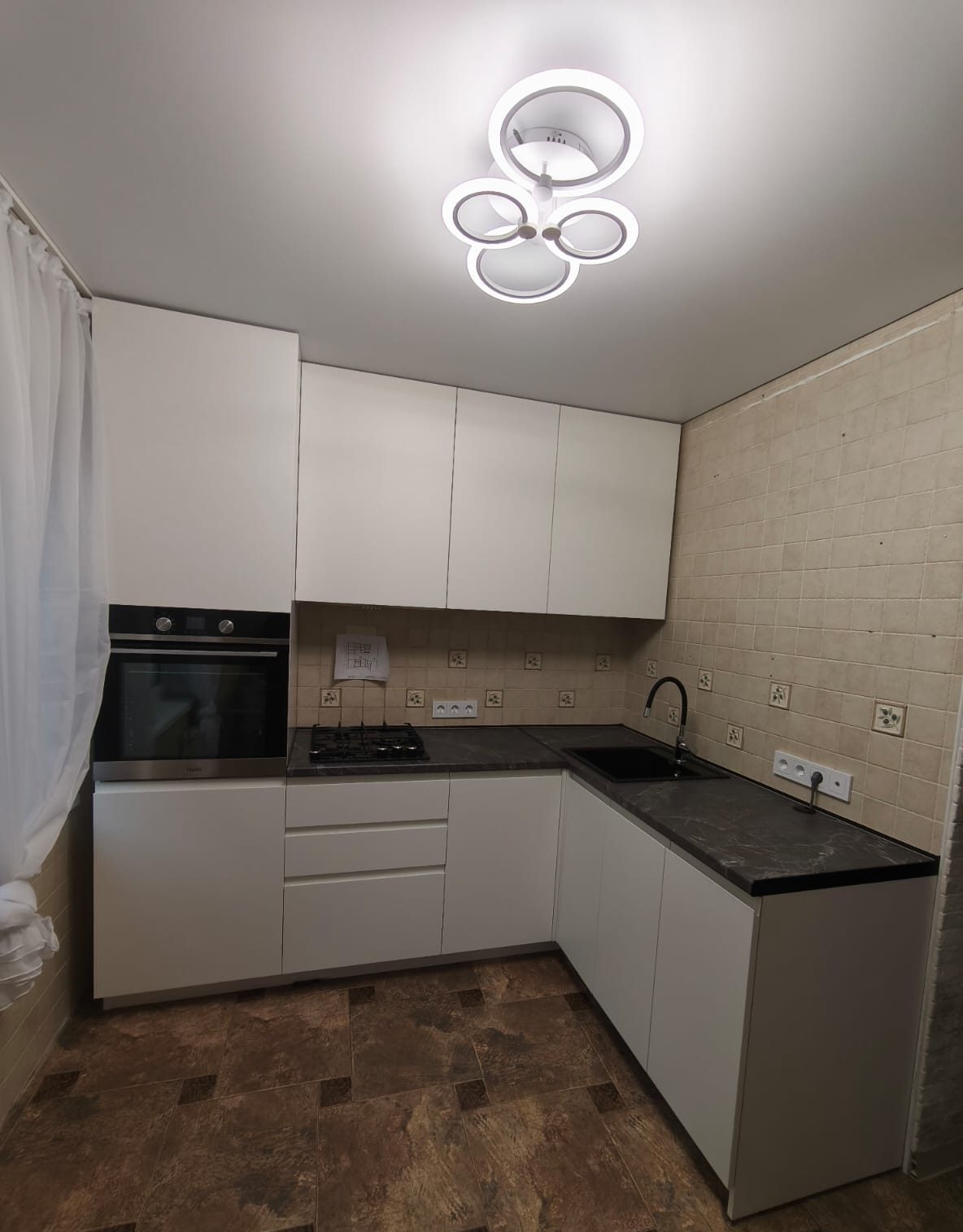 Угловая кухня для маленькой квартиры с интеграцией кухонных и бытовых приборов - фото